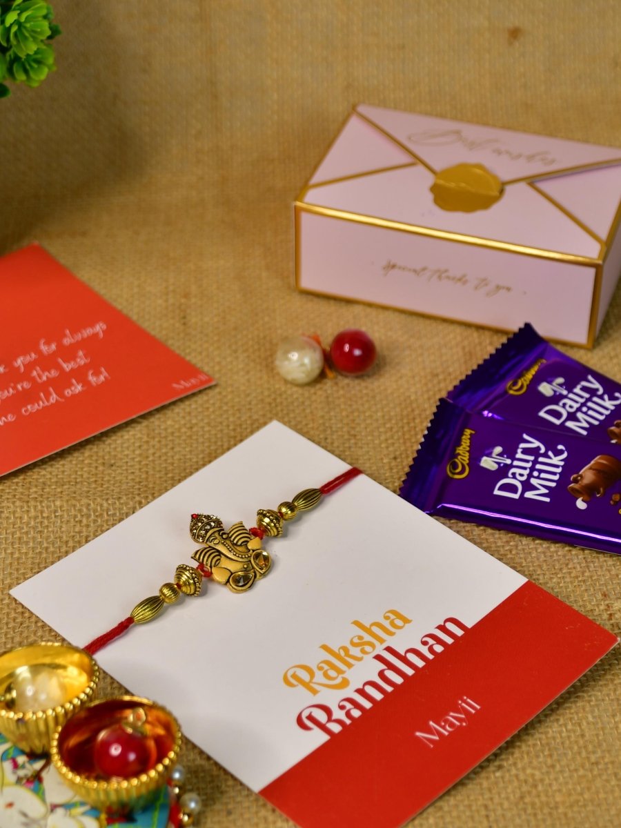 Sowpeace Exquisite Golden Ganesha Rakhi Pack of 1 with Roli Chawal Thali, Chocolates, and Greeting card combo for Raksha Bandhan and Gifting - Rakhi - Sowpeace - Sowpeace Exquisite Golden Ganesha Rakhi Pack of 1 with Roli Chawal Thali, Chocolates, and Greeting card combo for Raksha Bandhan and Gifting - RAK - GNS - HND - P3 - Sowpeace