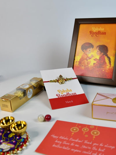 Sowpeace Exquisite Golden Ganesha Rakhi Pack of 1 with Roli Chawal Thali, Chocolates, Photo Frame and Greeting card combo for Raksha Bandhan and Gifting